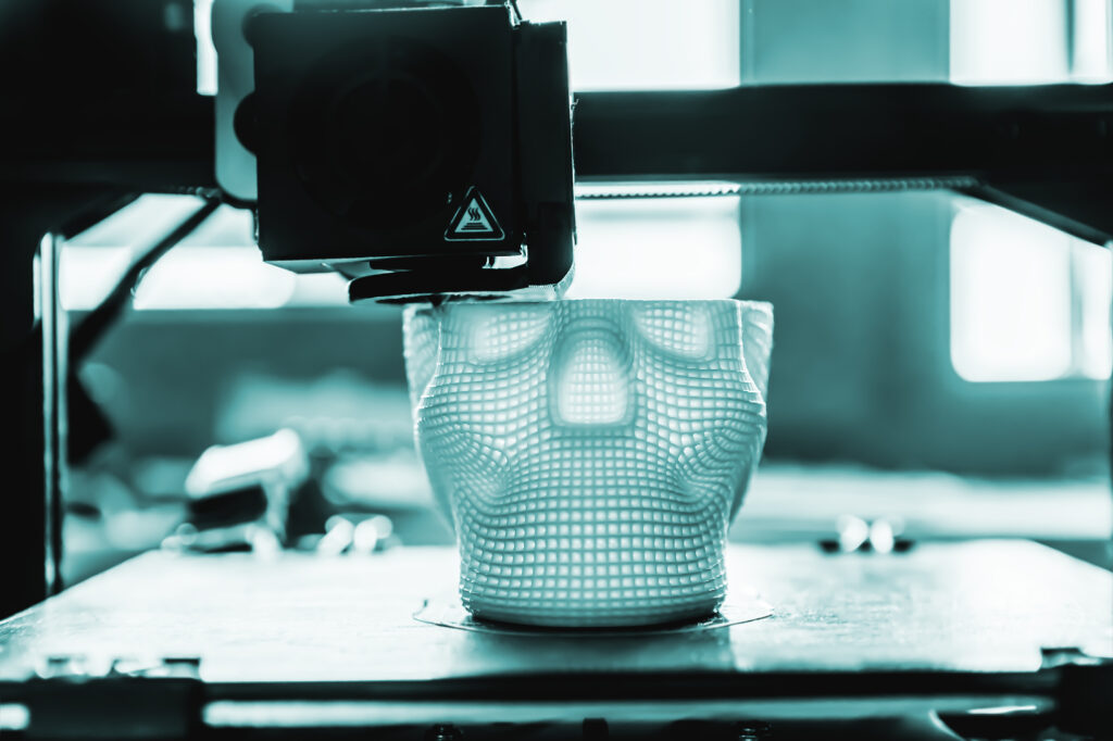 The 3D printer prints white plastic model of skull. modern technology.