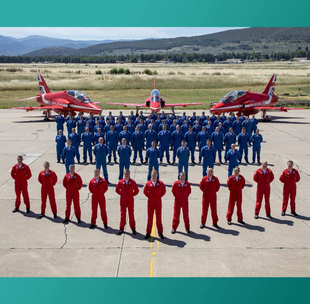 Image of HM Forces men in blue and red and two red fighter jets