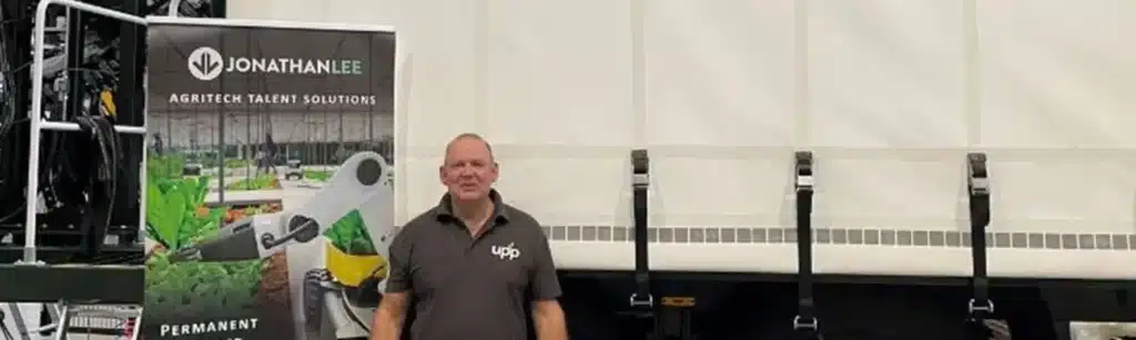 Man standing by a lorry and Jonathan Lee Agritech pull up banner