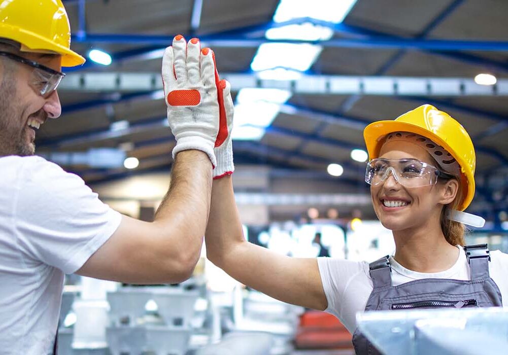 Two workers doing a high five in a warehouse