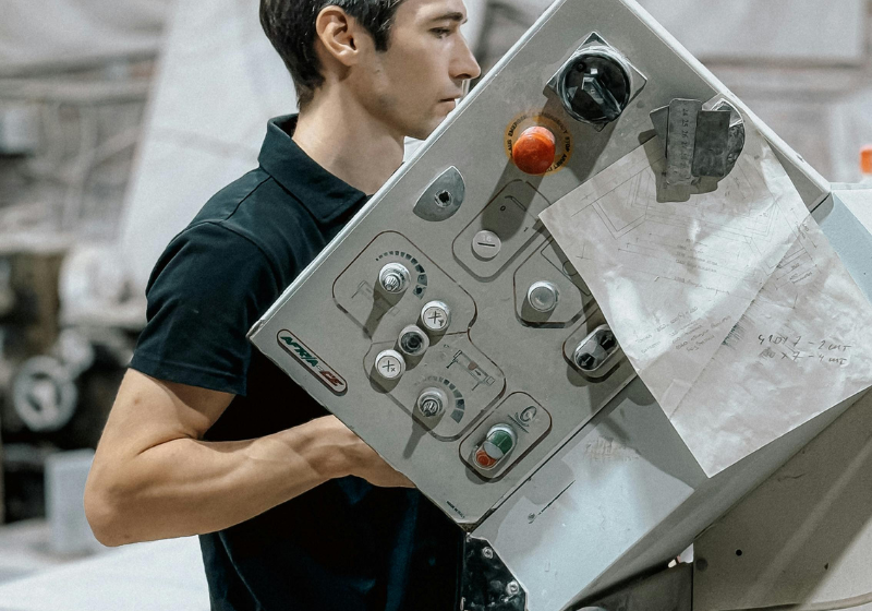 Young Man Operating Industrial Machinery Indoors